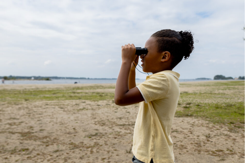 Een schoolklas krijgt een strandles aan het water