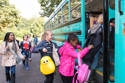 Kinderen stappen in de Stad & Natuurbus voor een excursie